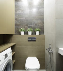 Laundry bathroom showing washing machine, toilet and tiling